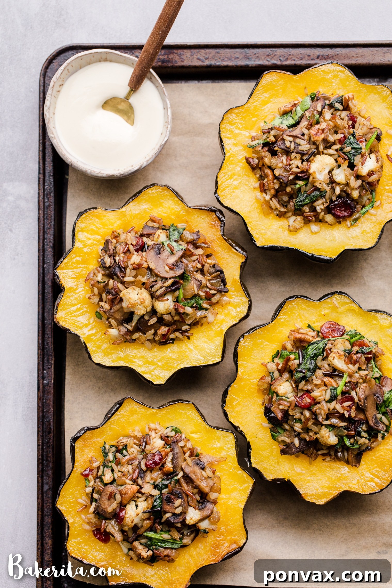 This Mushroom & Wild Rice Stuffed Acorn Squash is filled with caramelized onions, cauliflower florets, spinach, dried cranberries, and pecans. It's served with a drizzle of lemon tahini sauce. This comforting and colorful dish has a variety of texture, tons of flavor, and makes the perfect hearty dinner or side dish.