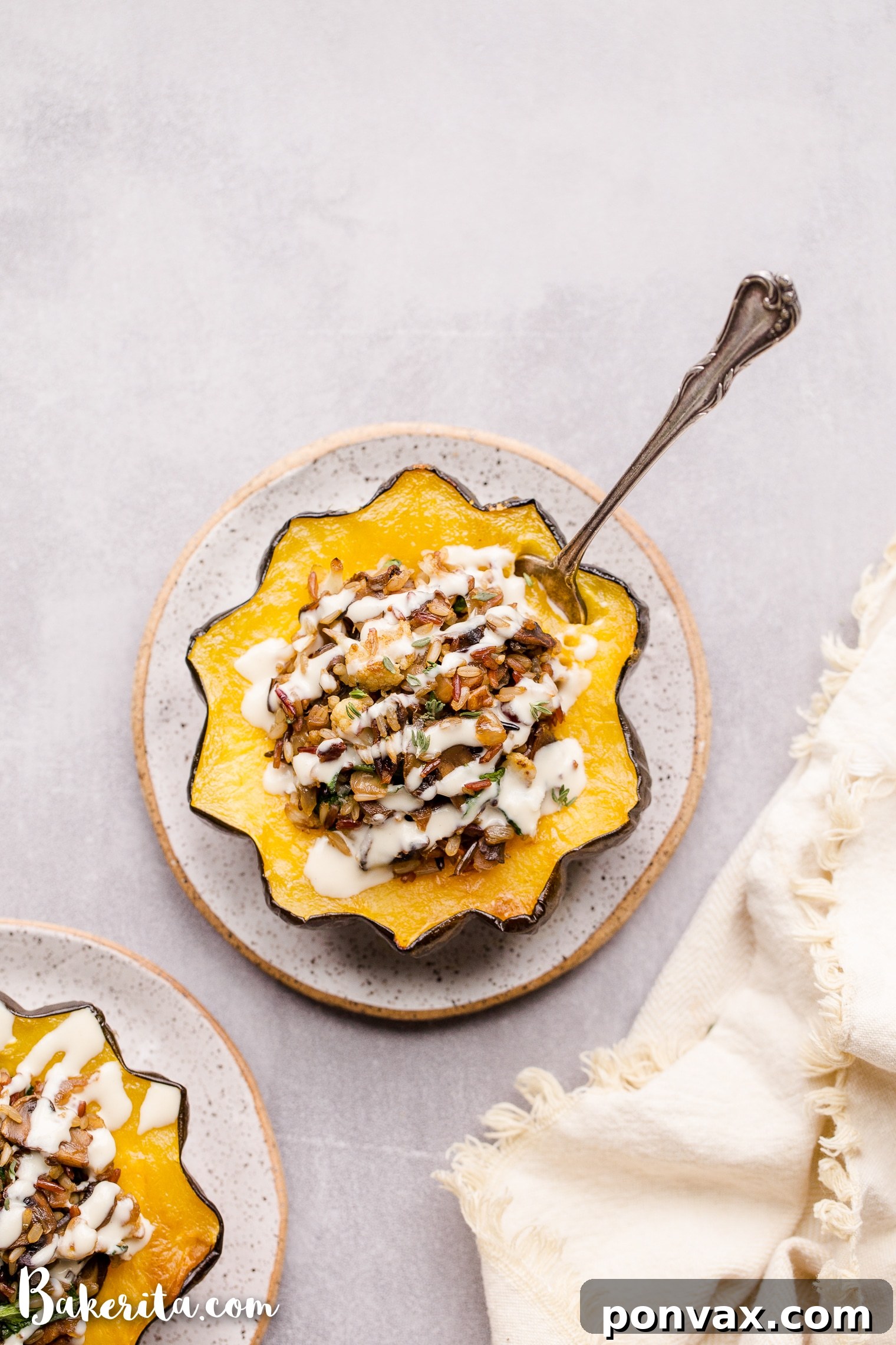 This Mushroom & Wild Rice Stuffed Acorn Squash is filled with caramelized onions, cauliflower florets, spinach, dried cranberries, and pecans. It's served with a drizzle of lemon tahini sauce. This comforting and colorful dish has a variety of texture, tons of flavor, and makes the perfect hearty dinner or side dish.