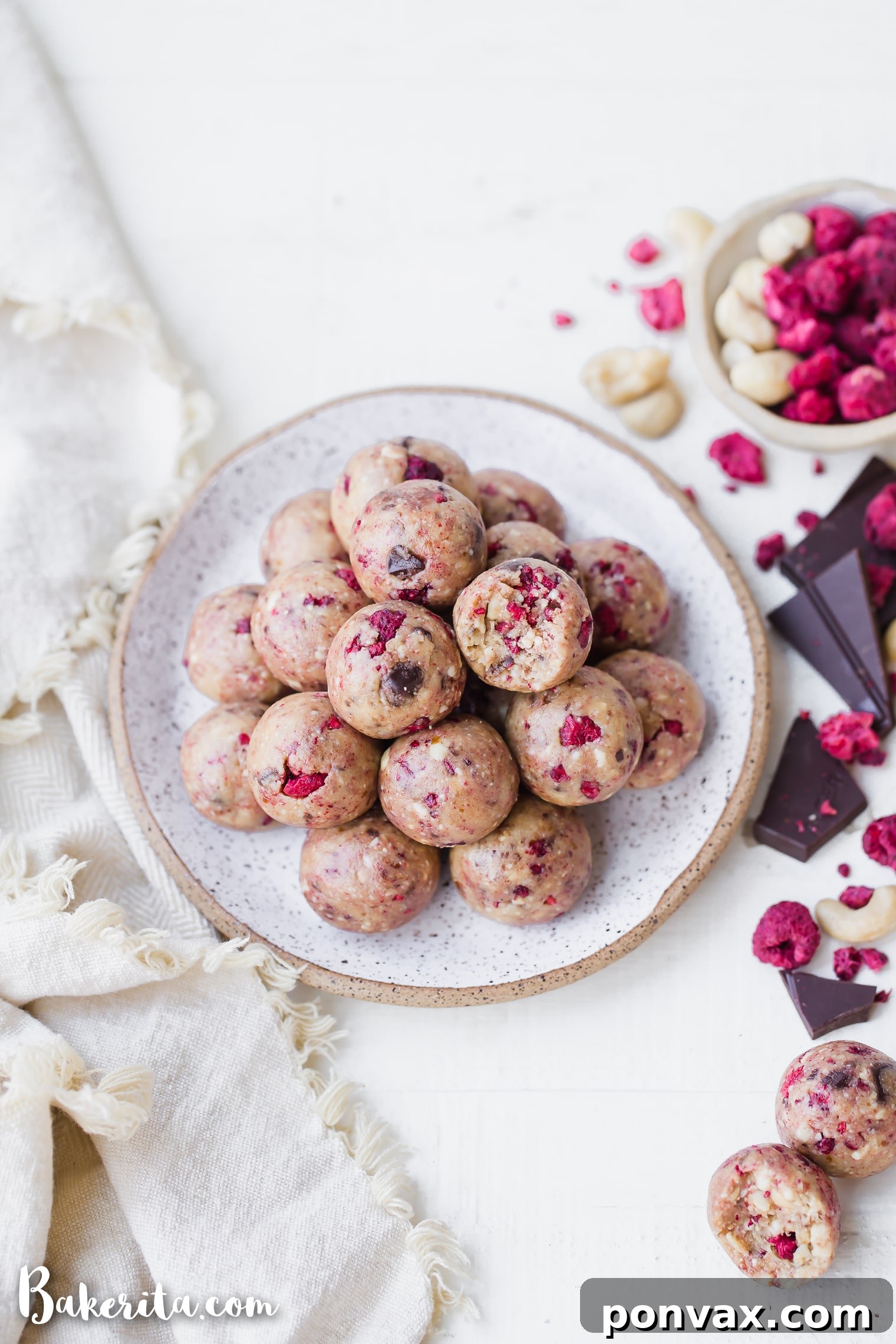 Raspberry Dark Chocolate Power Bites Gluten Free Paleo Vegan 3 A hand reaching for a Raspberry Dark Chocolate Energy Bite, highlighting its inviting texture.