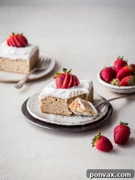 Gluten-Free Tres Leches Cake topped with whipped coconut cream and fresh strawberries