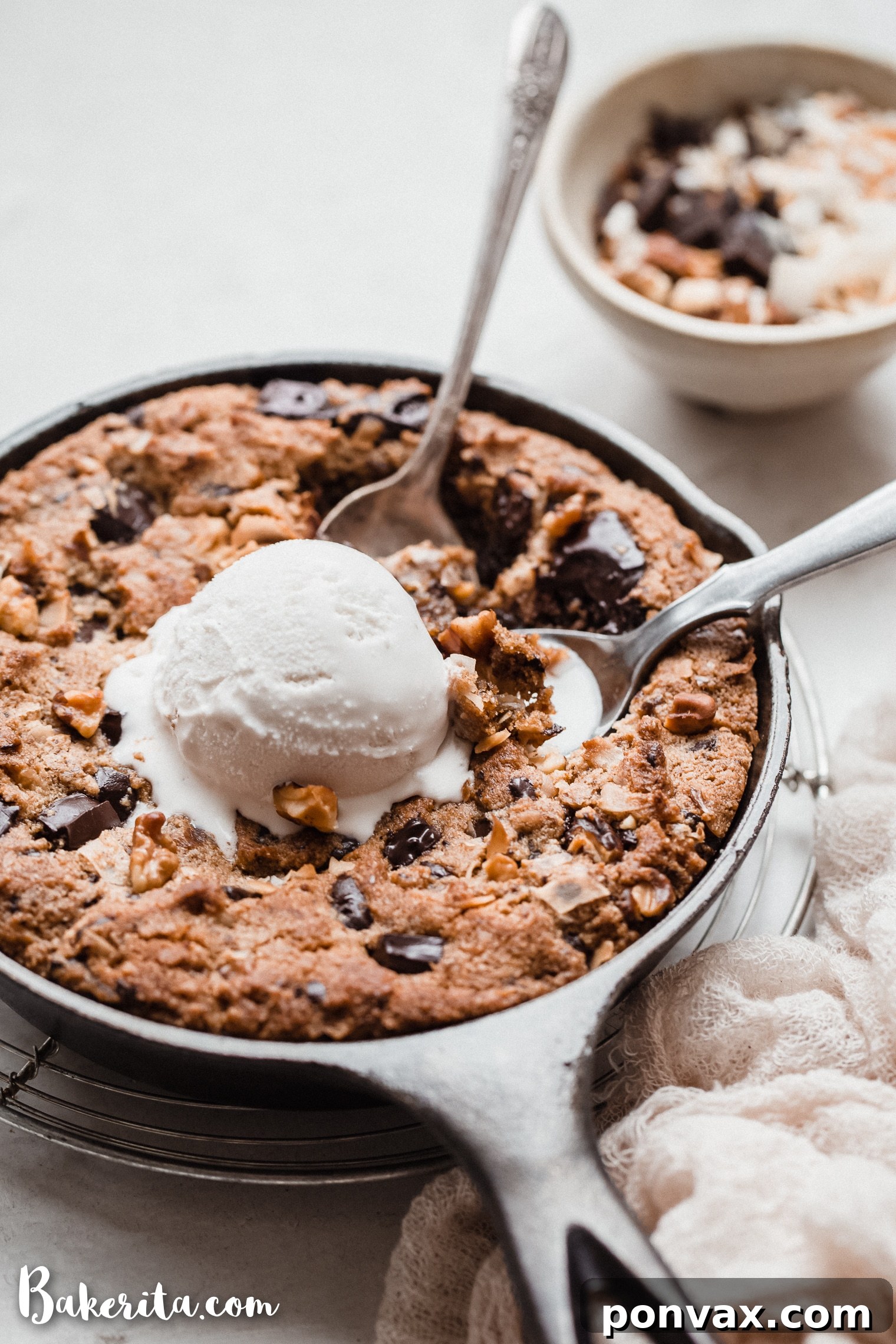 Irresistible Gluten-Free Skillet Chocolate Chip Cookie 3 Close-up of a warm Magic Chocolate Chip Skillet Cookie, showcasing its crispy edges and soft, melted center with visible chocolate, walnuts, and toasted coconut. It's a gluten-free and vegan dessert perfect for sharing.