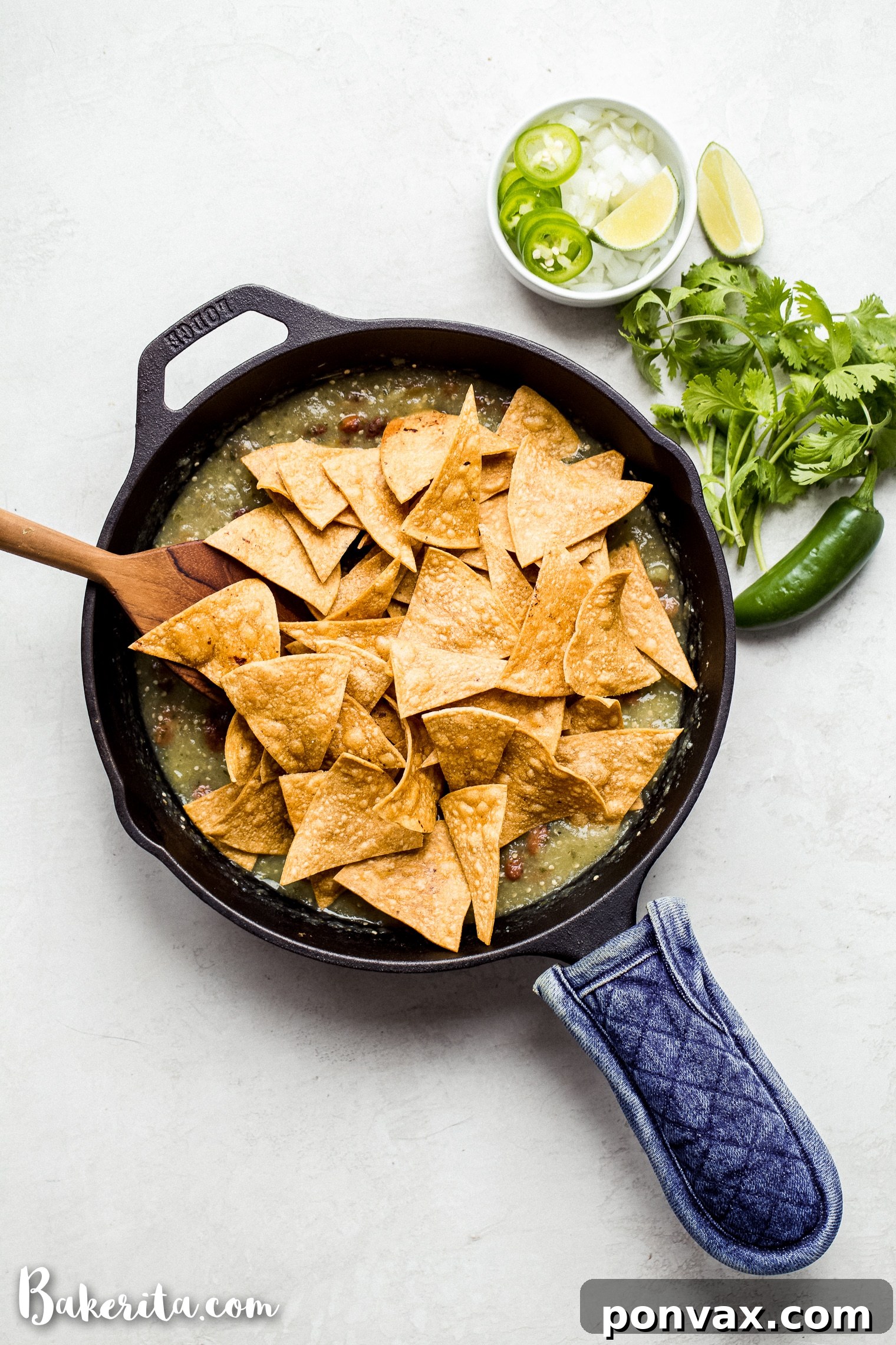 Close-up of freshly prepared guacamole with a basket of totopos (tortilla chips) on a wooden table, evoking authentic Mexican dining.