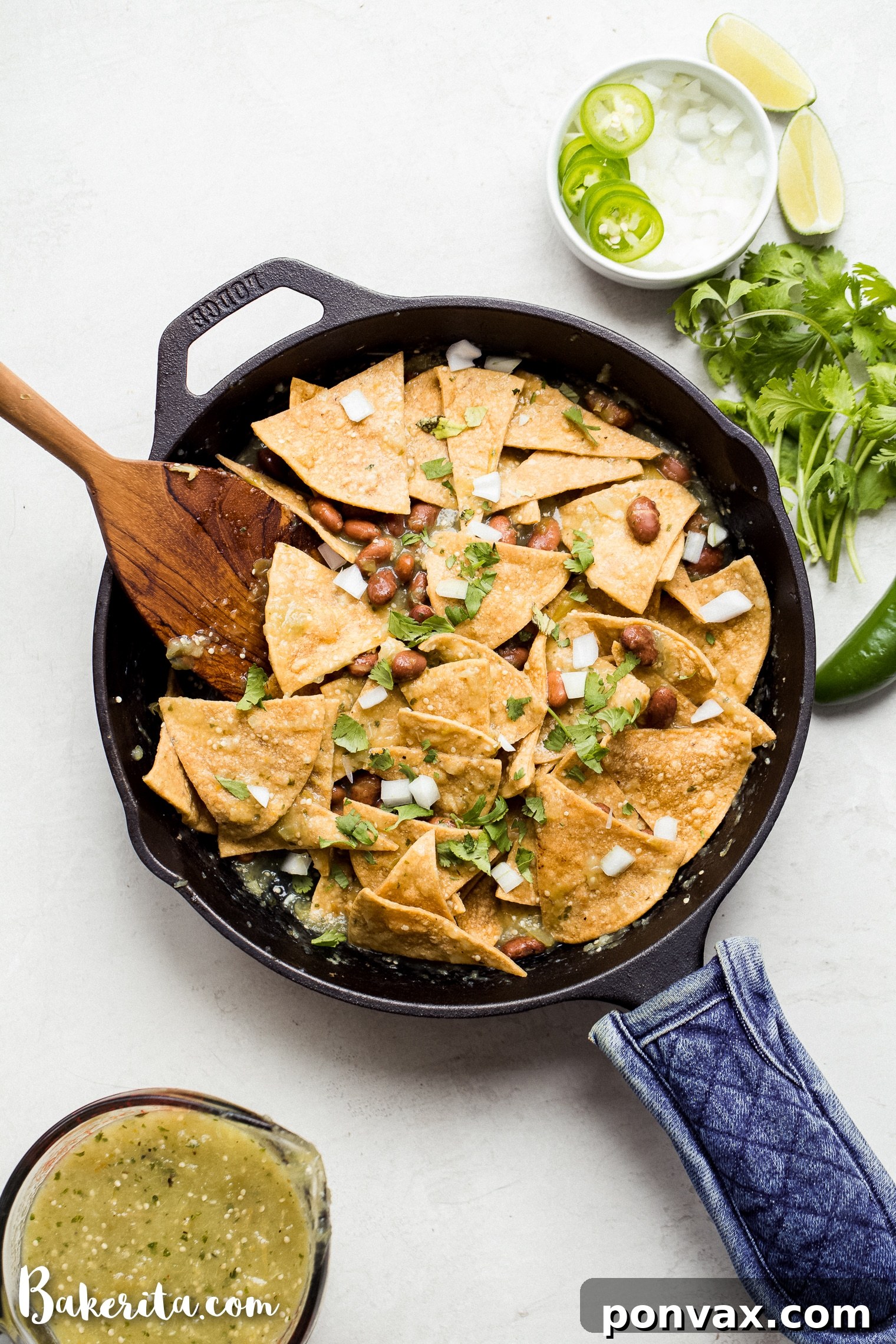 A vibrant platter of Vegan Chilaquiles Verdes topped with avocado slices, cilantro, and a generous drizzle of creamy vegan sour cream, ready to be served.