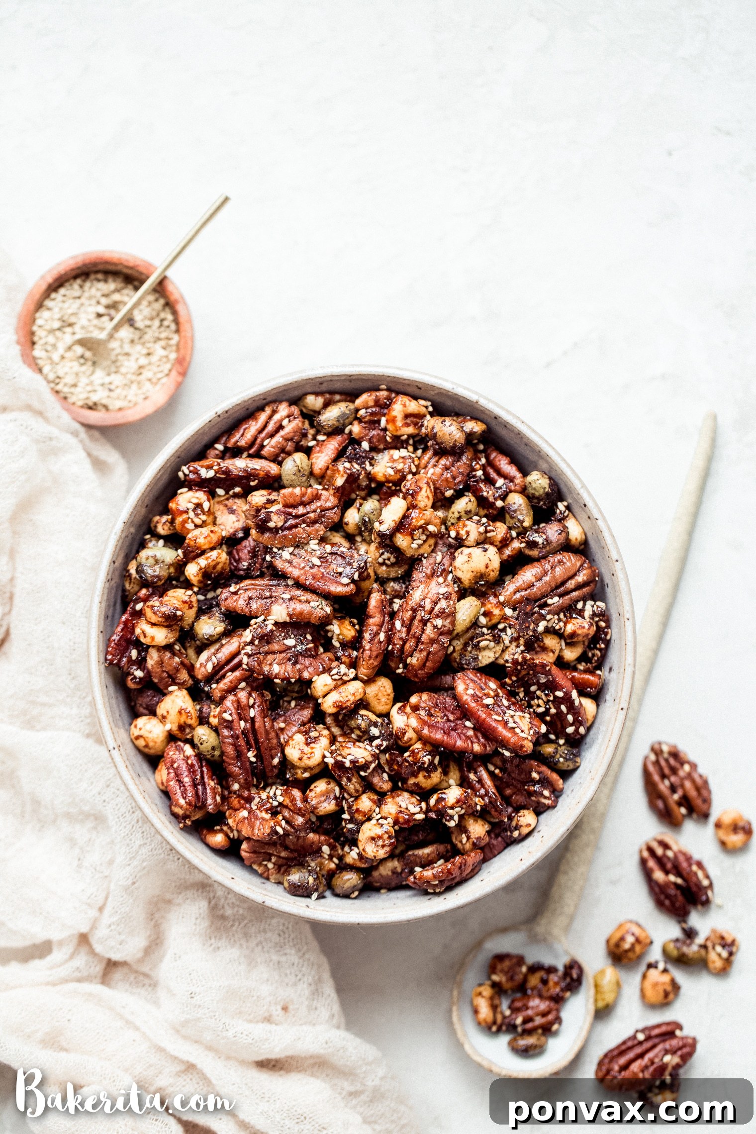 A vibrant close-up of the Sesame Tamari Pecan Snack Mix, showcasing perfectly toasted pecans, crunchy corn kernels, and edamame, all glazed with a savory-sweet tamari sauce.