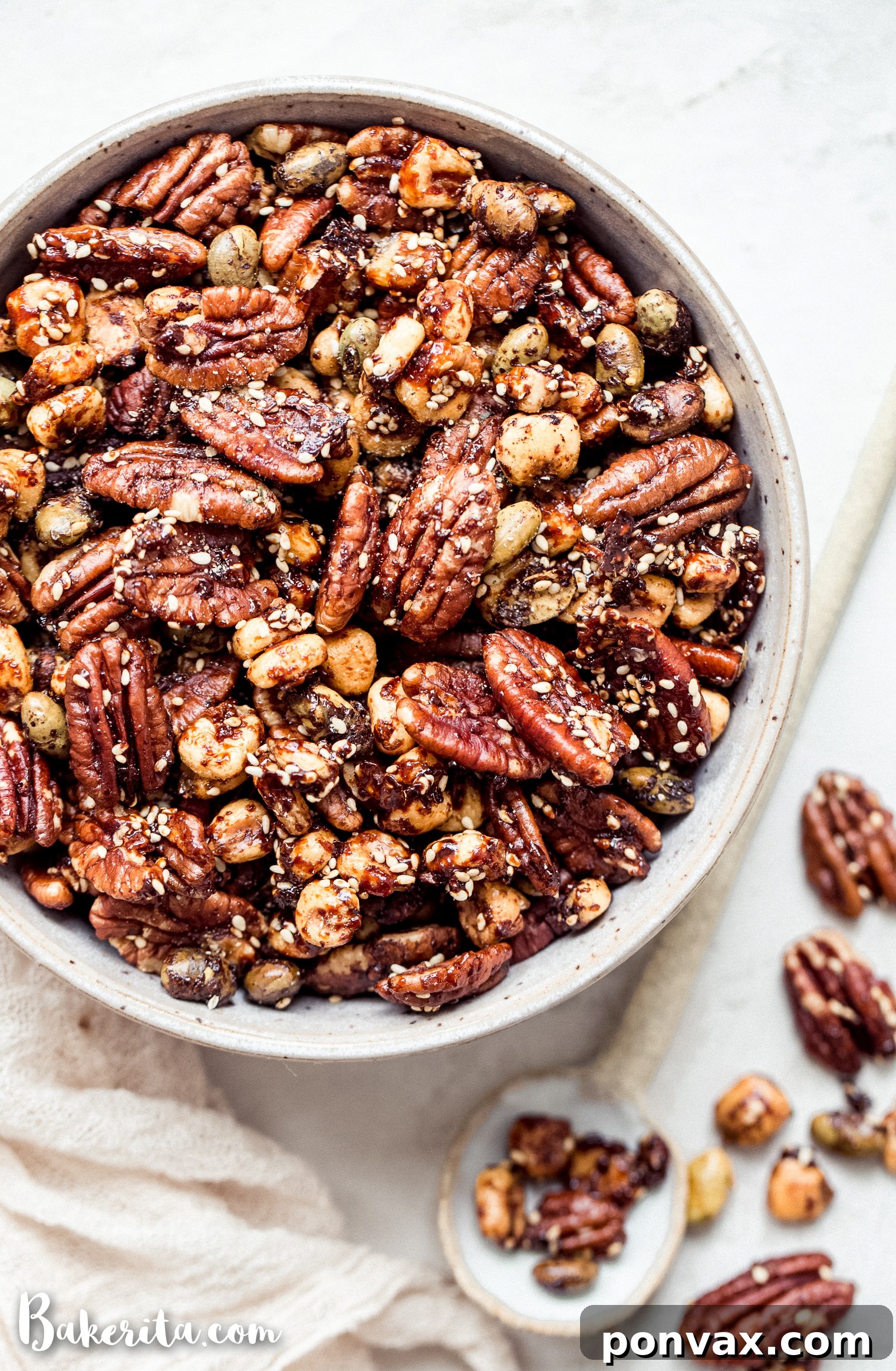 A small serving bowl filled with the delectable Sesame Tamari Pecan Snack Mix, highlighting its golden-brown texture and appealing mix of ingredients.