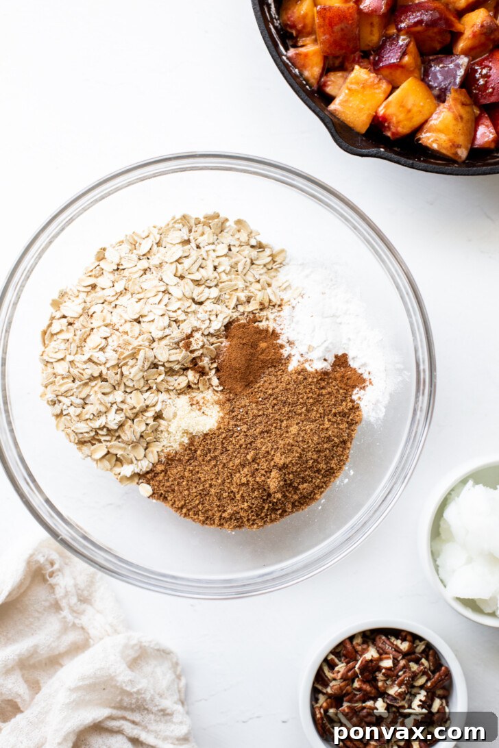 A serving of warm peach crisp topped with a scoop of vanilla ice cream.