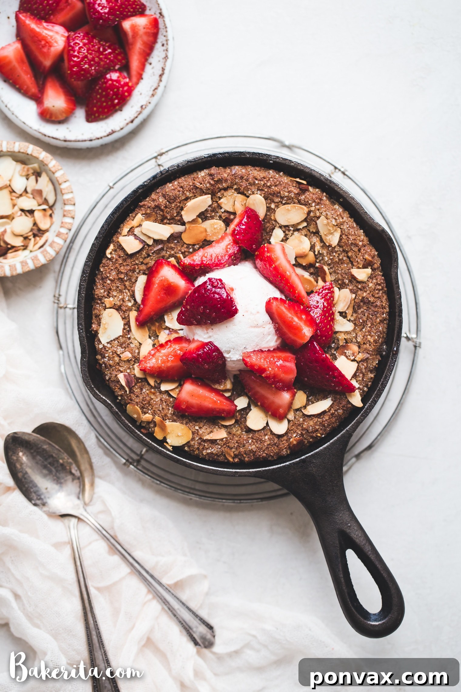 A perfectly baked Gluten-Free & Vegan Sugar Cookie Skillet, garnished with sliced almonds and turbinado sugar, ready to be served.