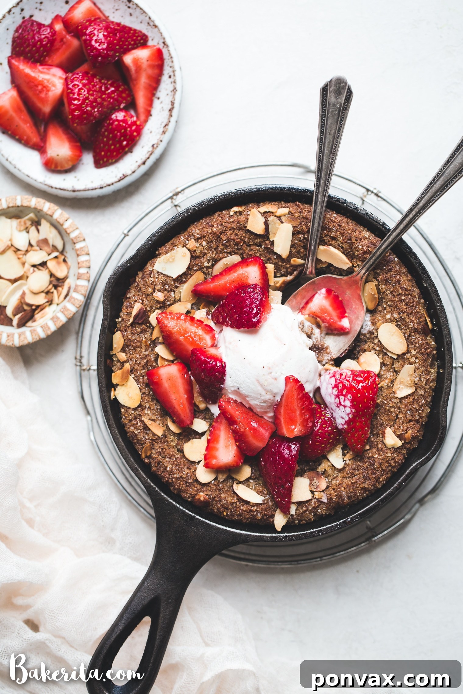 A slice of Gluten-Free & Vegan Sugar Cookie Skillet served with a scoop of dairy-free ice cream and fresh strawberries, a perfect dessert.