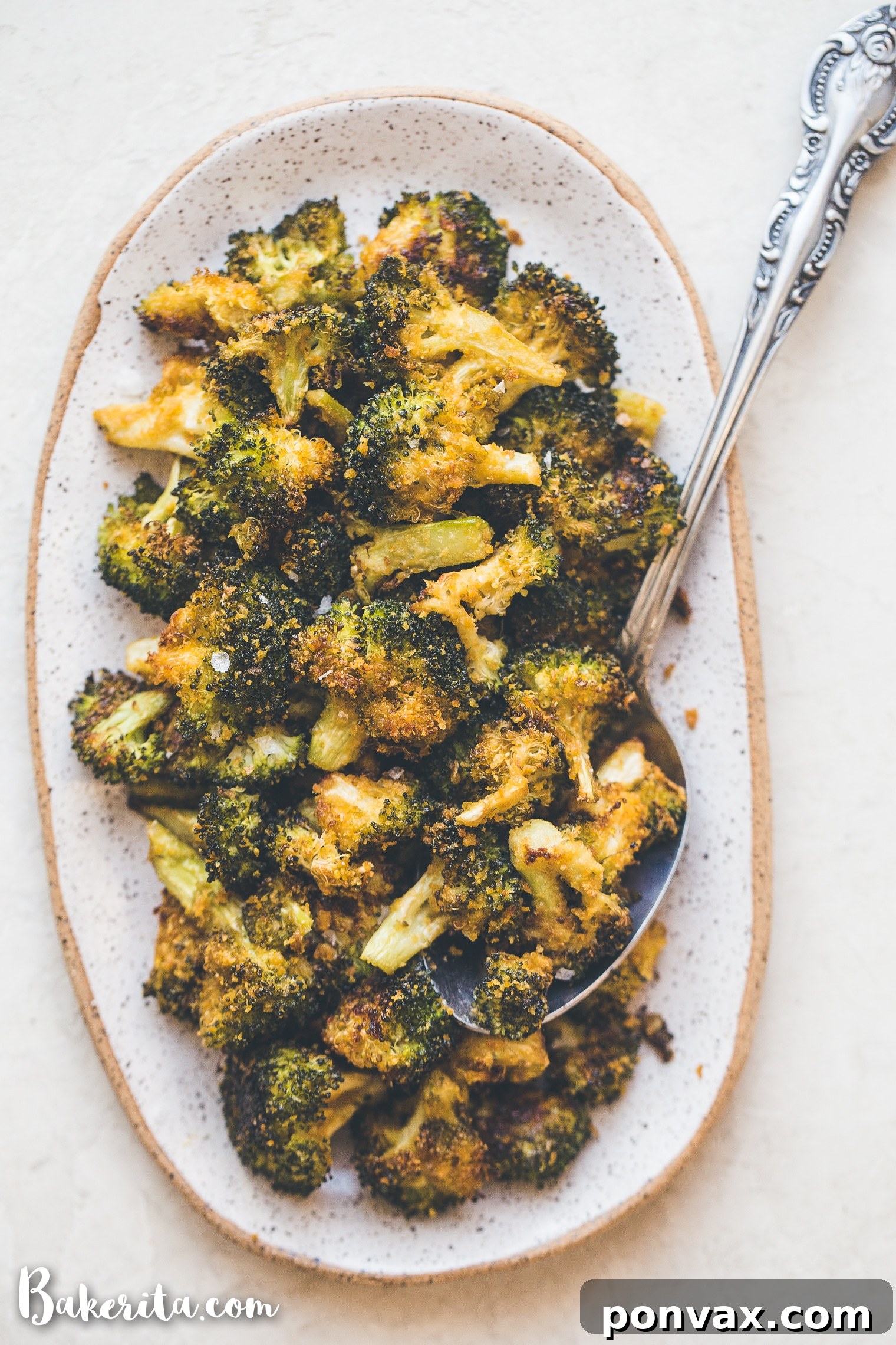 Close-up of golden-brown roasted broccoli florets seasoned with nutritional yeast.