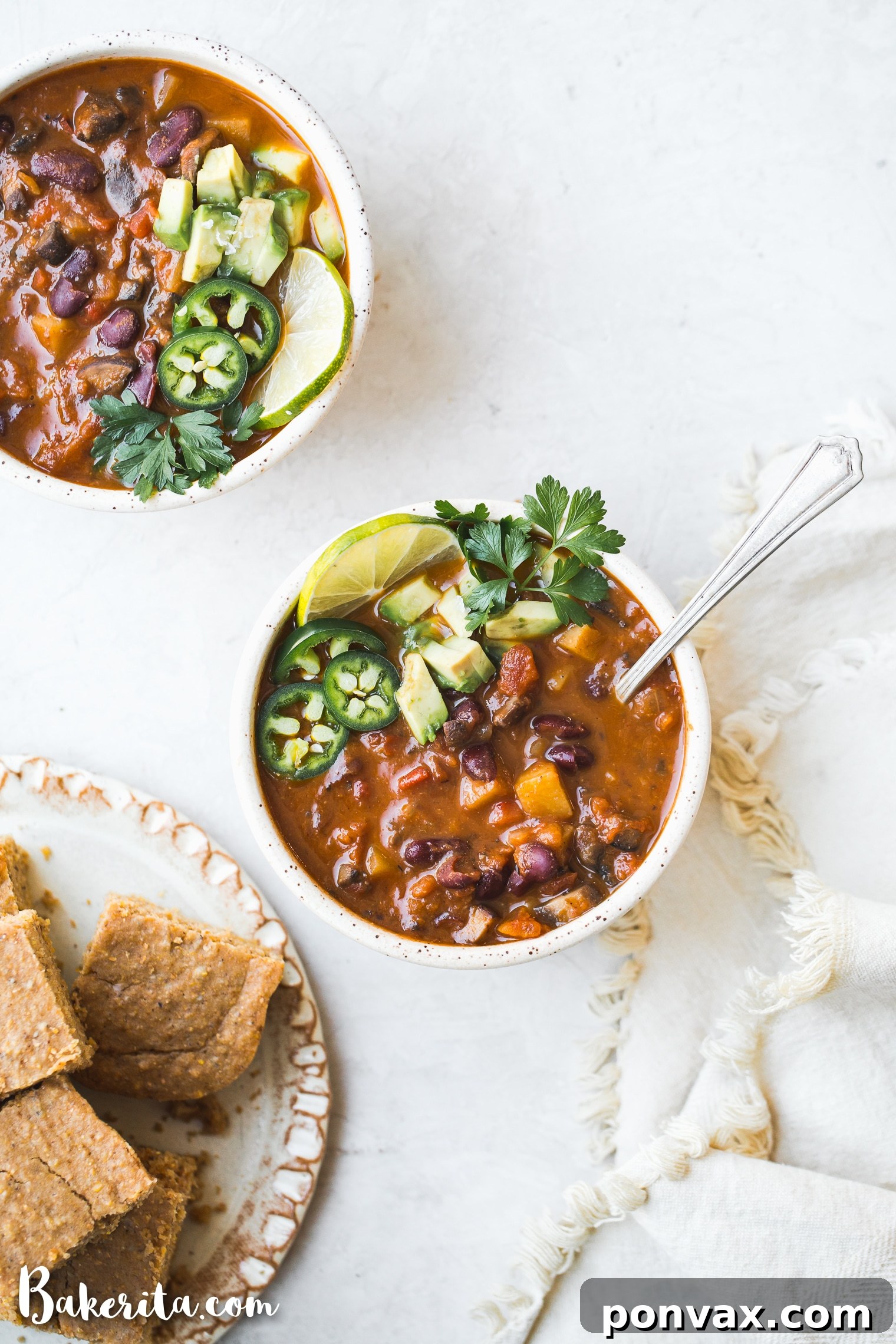 A steaming bowl of hearty vegan chili, garnished with fresh cilantro and a dollop of dairy-free sour cream.