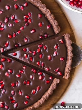 This No-Bake Chocolate Pomegranate Tart is made with 8 simple ingredients and is perfect for holiday entertaining! No baking required for this gluten-free, paleo, and vegan tart.