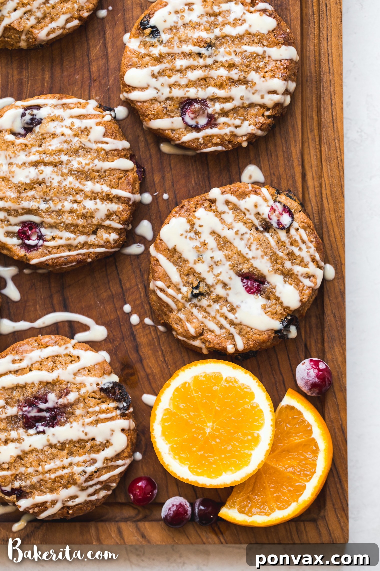 Freshly baked gluten-free vegan cranberry orange scones with a delicate orange glaze, artfully arranged on a serving plate.