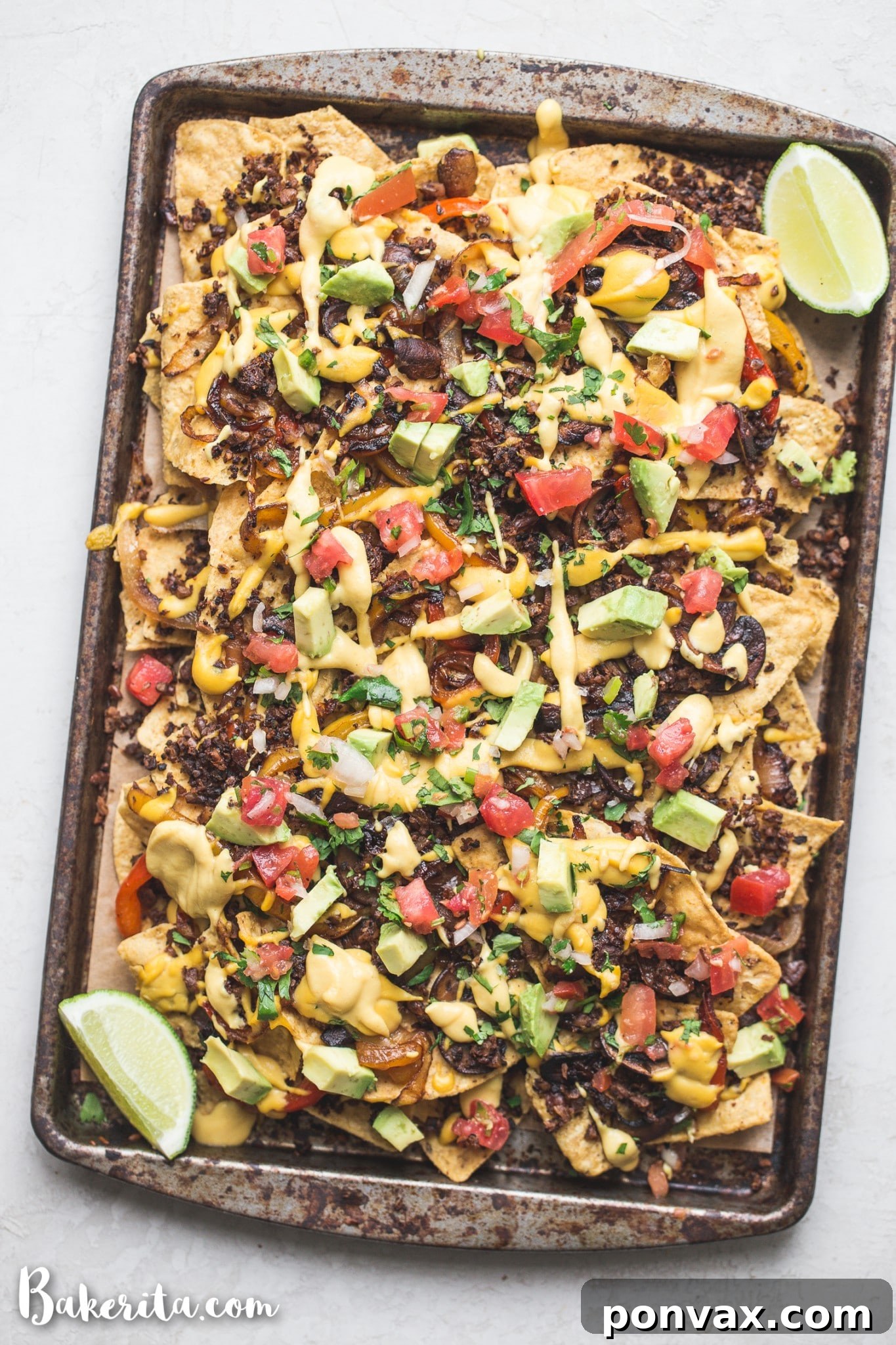 Another enticing shot of the best vegan nachos, garnished with fresh cilantro and lime wedges, emphasizing their fresh and inviting appearance.