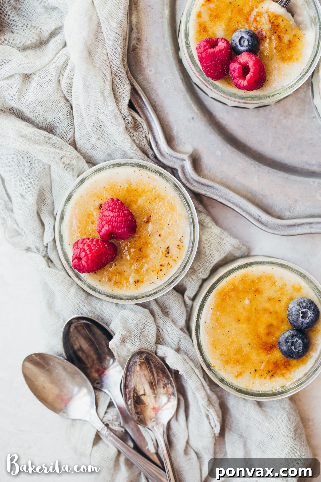 Three ramekins of Vegan Creme Brulee arranged on a table, with one showing the smooth custard before being torched.