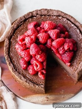 A delectable slice of Baked Vegan Chocolate Cheesecake, garnished with fresh berries.