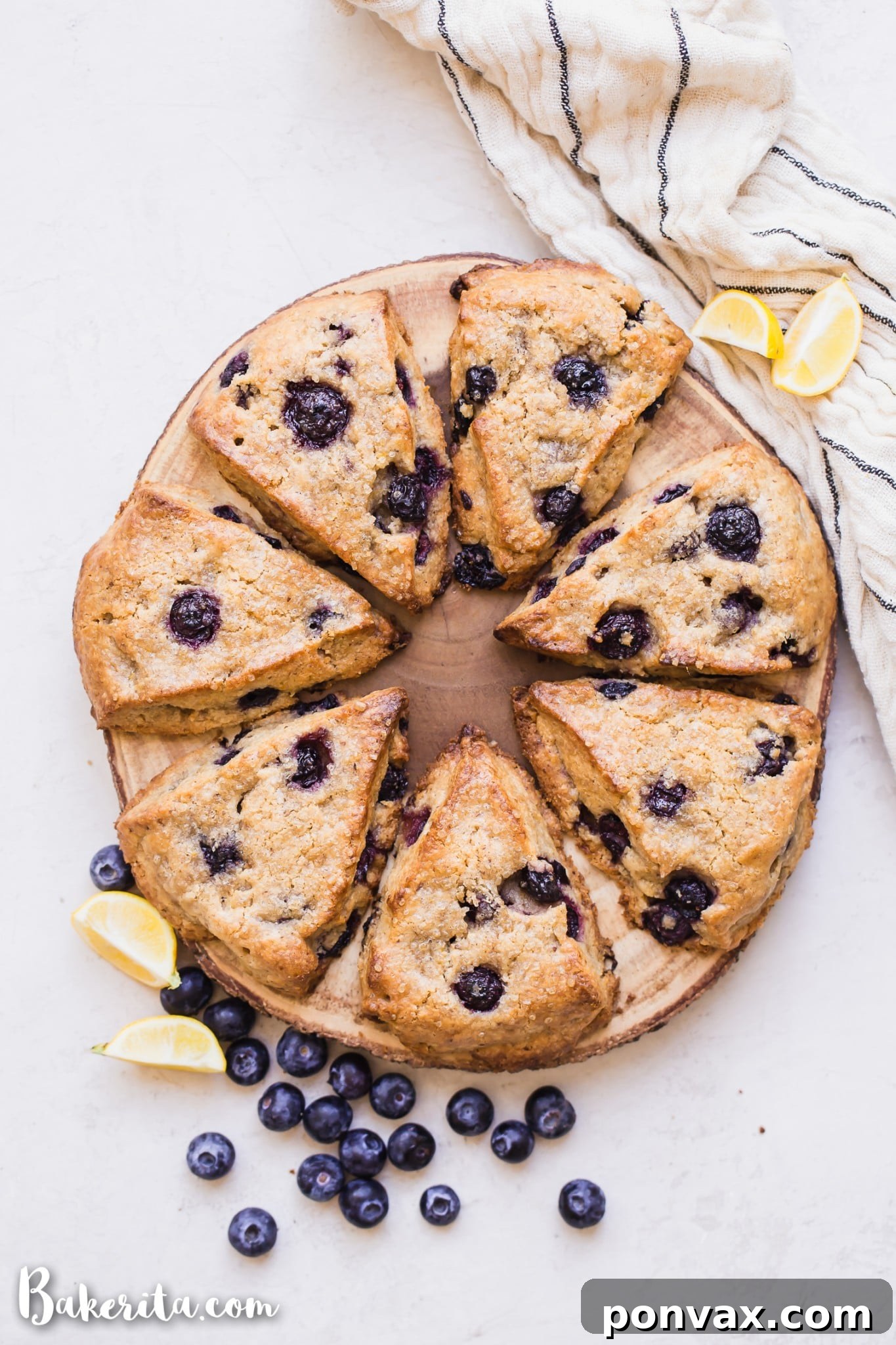 A stack of golden brown gluten-free vegan lemon blueberry scones on a wire rack, showcasing their fluffy texture and blueberry-studded interiors.