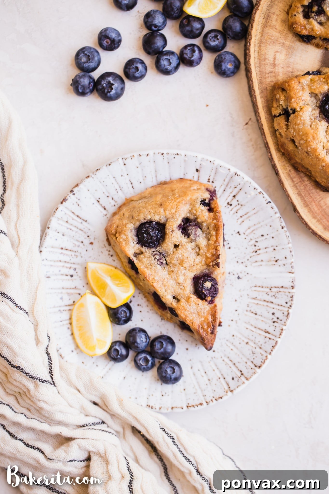 Close-up of a gluten-free vegan lemon blueberry scone, showing the golden crust, soft interior, and vibrant blueberries embedded within.