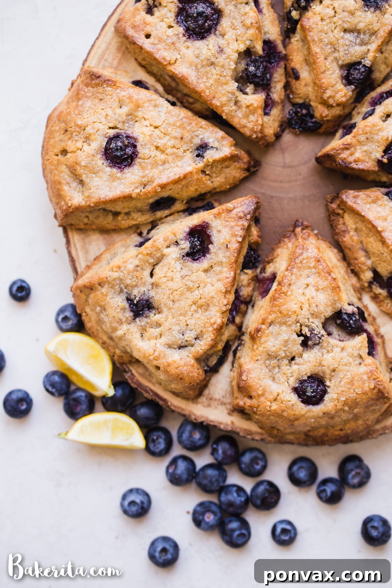 A platter of gluten-free vegan lemon blueberry scones, with one scone broken open to reveal its tender, blueberry-filled interior, ready to be enjoyed.