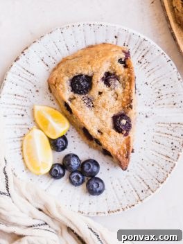 Gluten-Free Vegan Lemon Blueberry Scones with a tender texture and crispy exterior, full of bright, lemony flavor and bursting with blueberries.