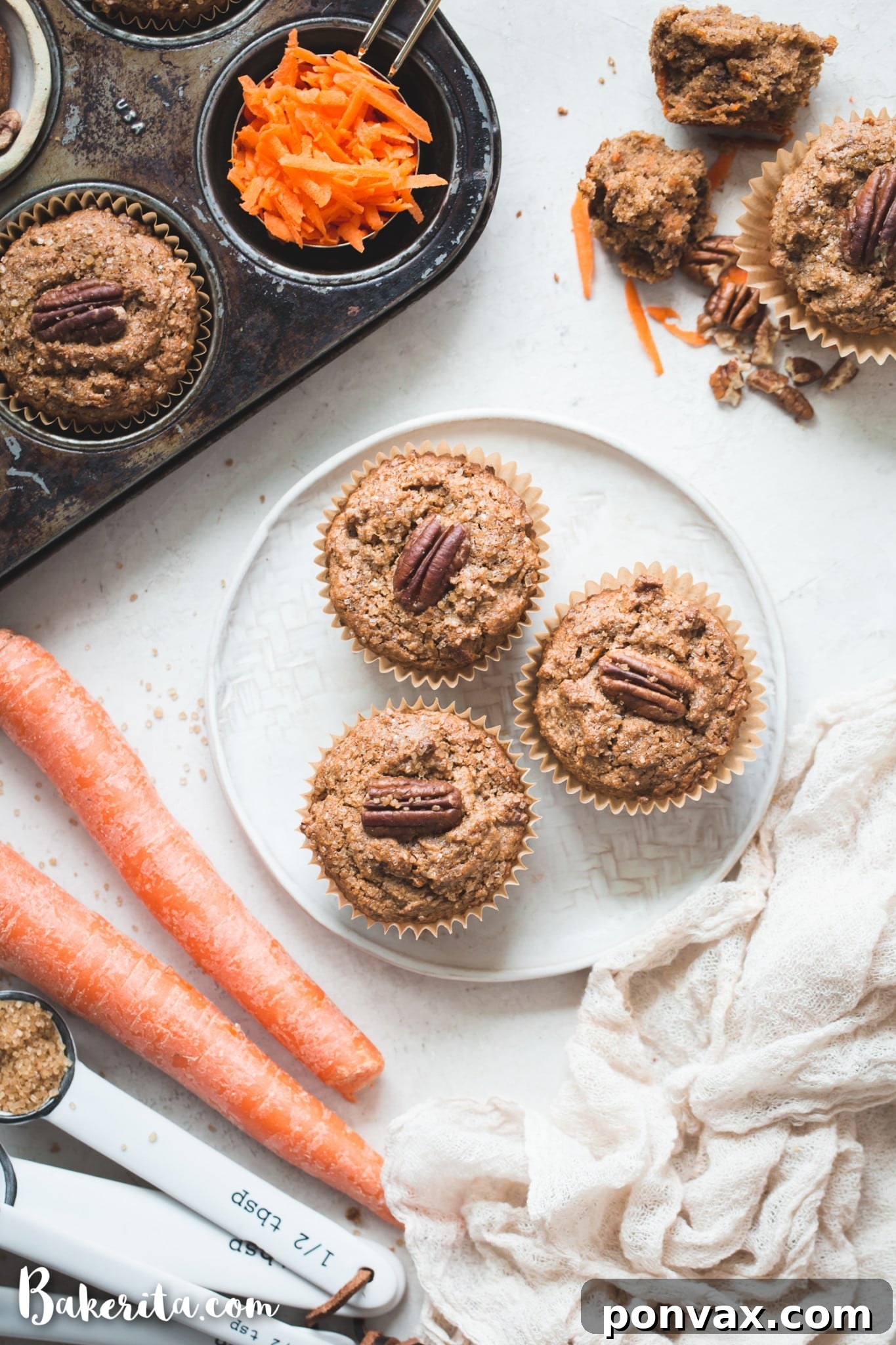 Perfectly Spiced Gluten-Free Vegan Carrot Cake Muffins 3 Close-up of a single Gluten-Free Vegan Carrot Cake Muffin, showcasing its moist interior with visible shreds of carrot and specks of spice, inviting a delicious bite.
