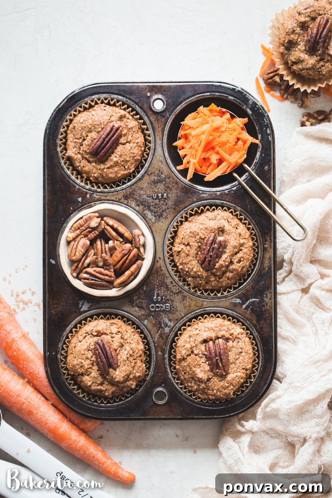 Perfectly Spiced Gluten-Free Vegan Carrot Cake Muffins 5 Various wet ingredients for vegan carrot cake muffins, including applesauce, almond milk, and melted coconut oil, being whisked together in a glass bowl.