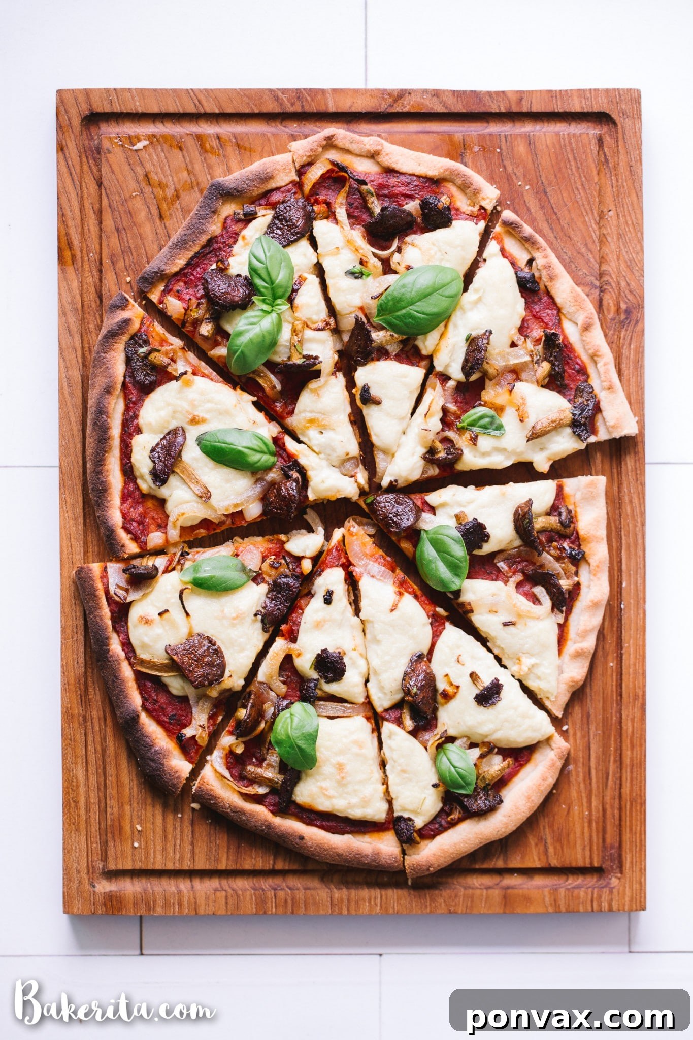 Delicious homemade Gluten-Free Vegan Pizza loaded with mushrooms and onions, resting on a wooden board ready to be sliced and served.