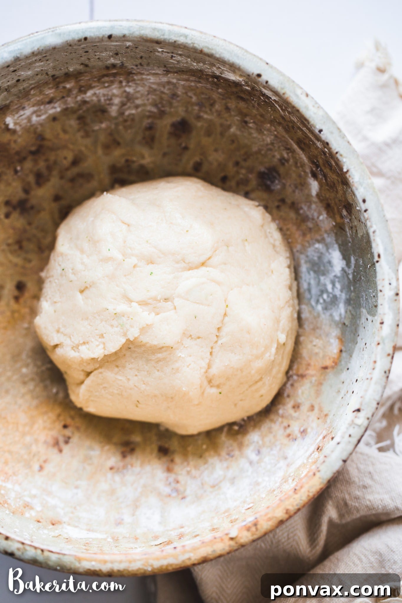 Ingredients for a gluten-free vegan pizza crust laid out on a table, including almond flour, tapioca flour, olive oil, baking powder, and salt.