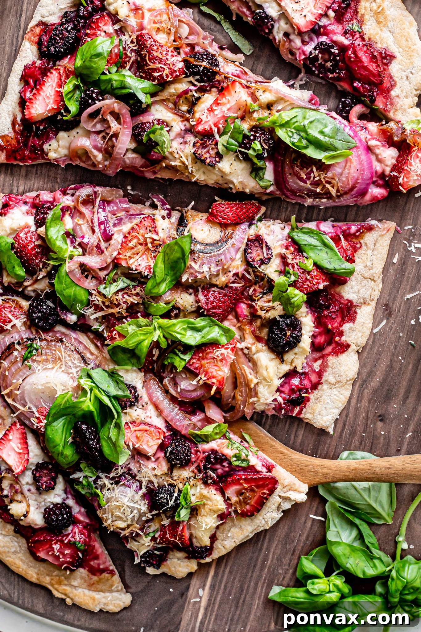 A colorful Strawberry Blackberry Basil Naan Pizza, garnished with fresh basil, showcasing a gluten-free and vegan crust.