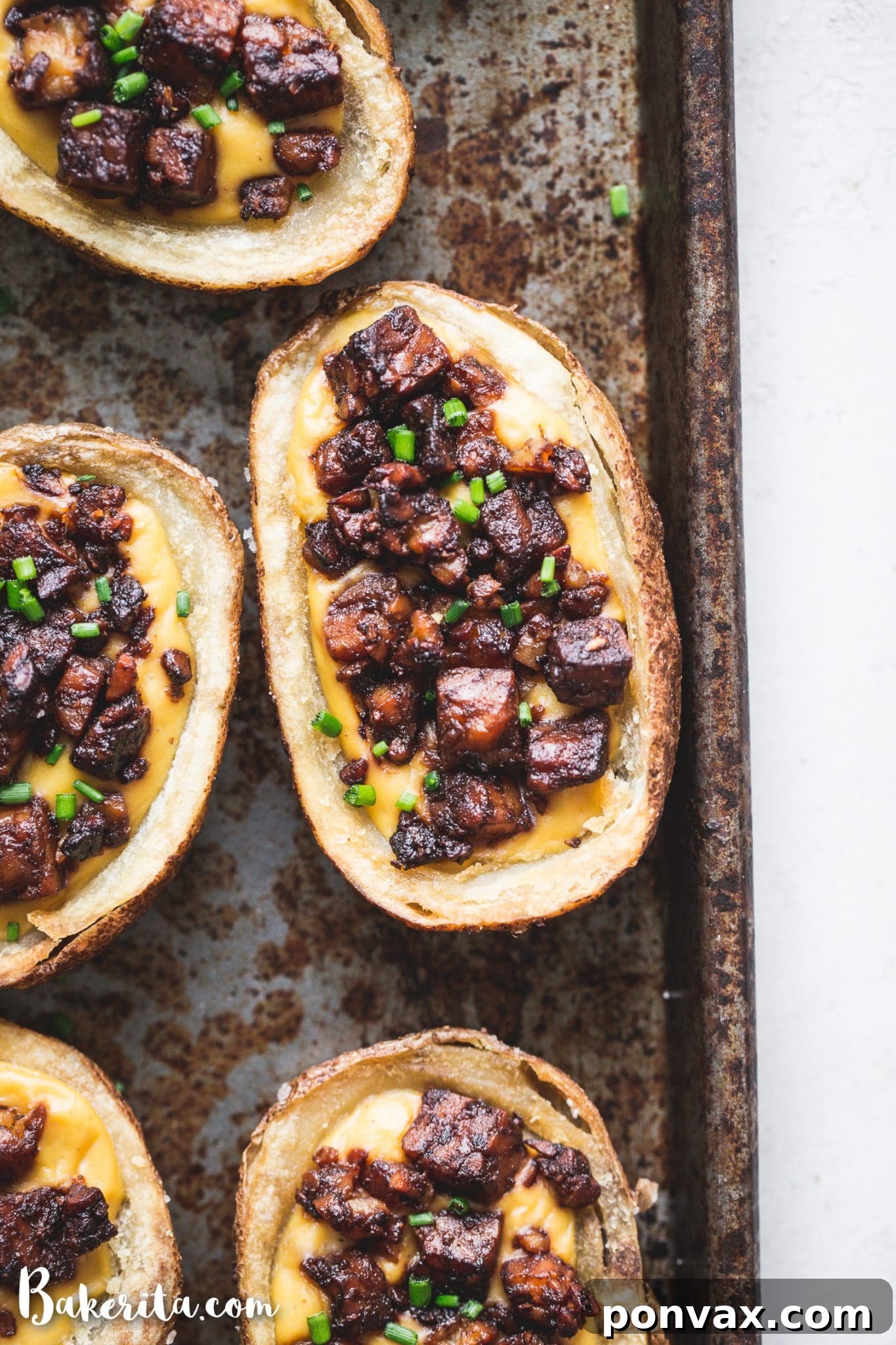 Multiple vegan potato skins arranged on a rustic wooden board, ready for serving.