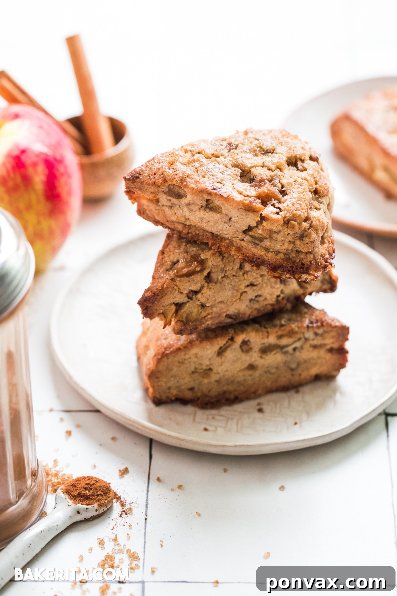 Close-up of the delicate, flaky texture of a Gluten-Free Vegan Apple Cinnamon Scone, with visible pieces of caramelized apple and chopped pecans.