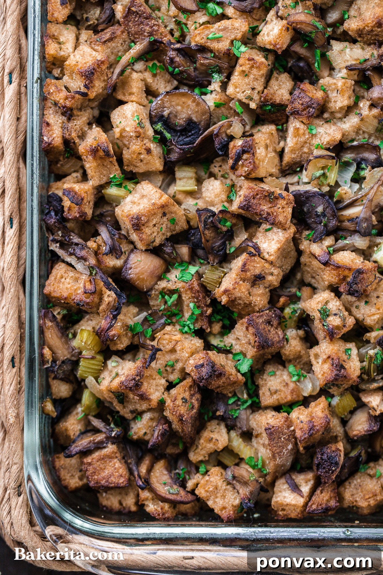A dish of Vegan Mushroom Stuffing, with a serving spoon poised to scoop out a portion, emphasizing its readiness to be enjoyed.