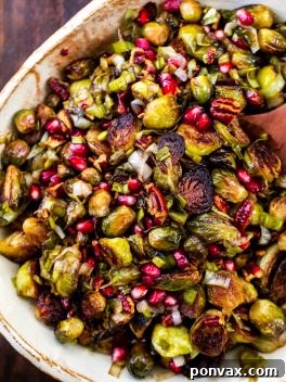 Overhead shot of Roasted Brussels Sprouts with Pomegranate & Pecans in a bowl, ready to serve.