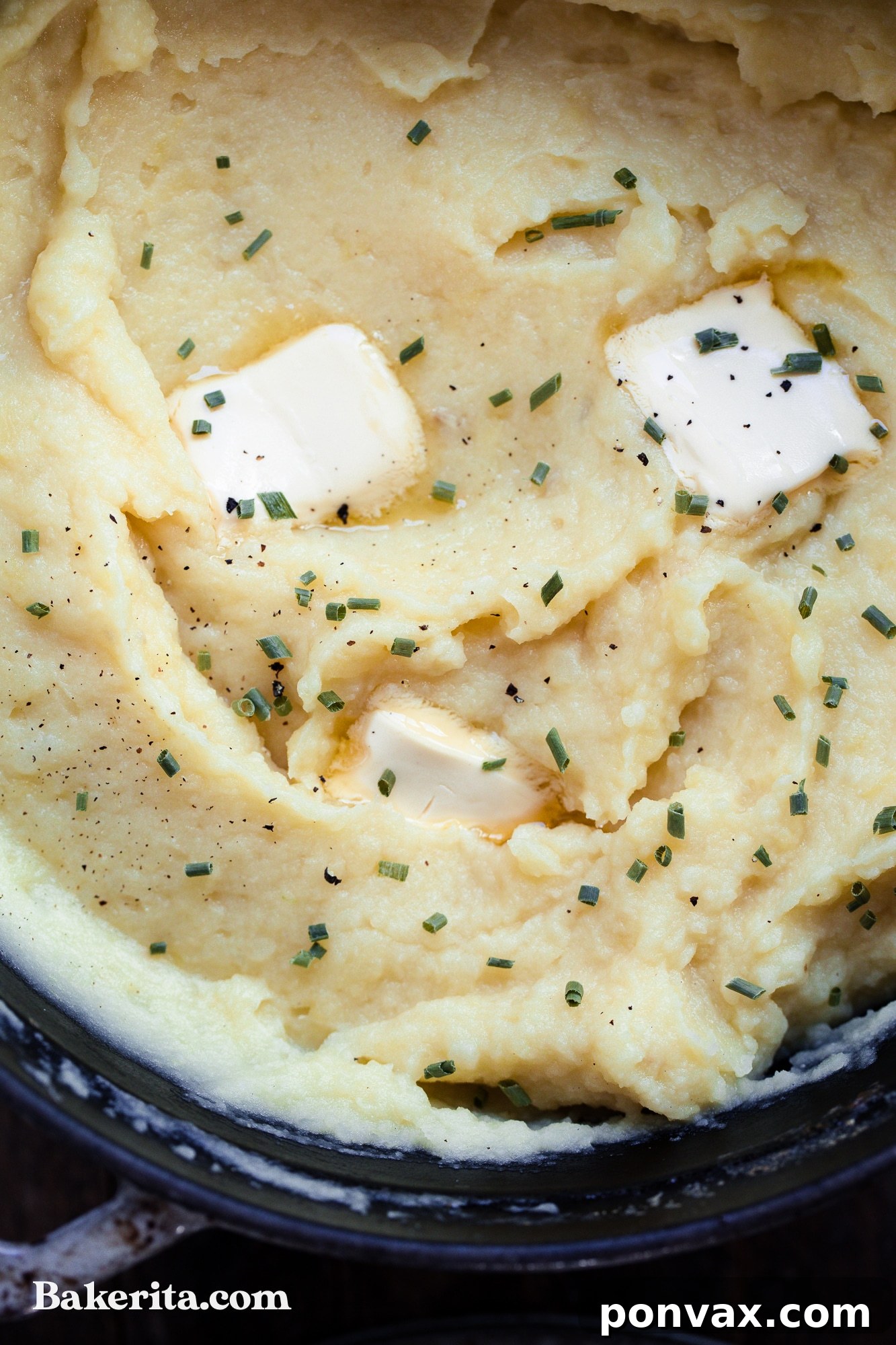 A bowl of creamy vegan mashed potatoes garnished with fresh chives, ready to be served.