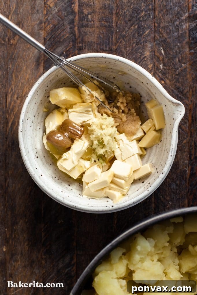 A bowl of vegan mashed potatoes garnished with chives, ready to be served at a holiday meal.