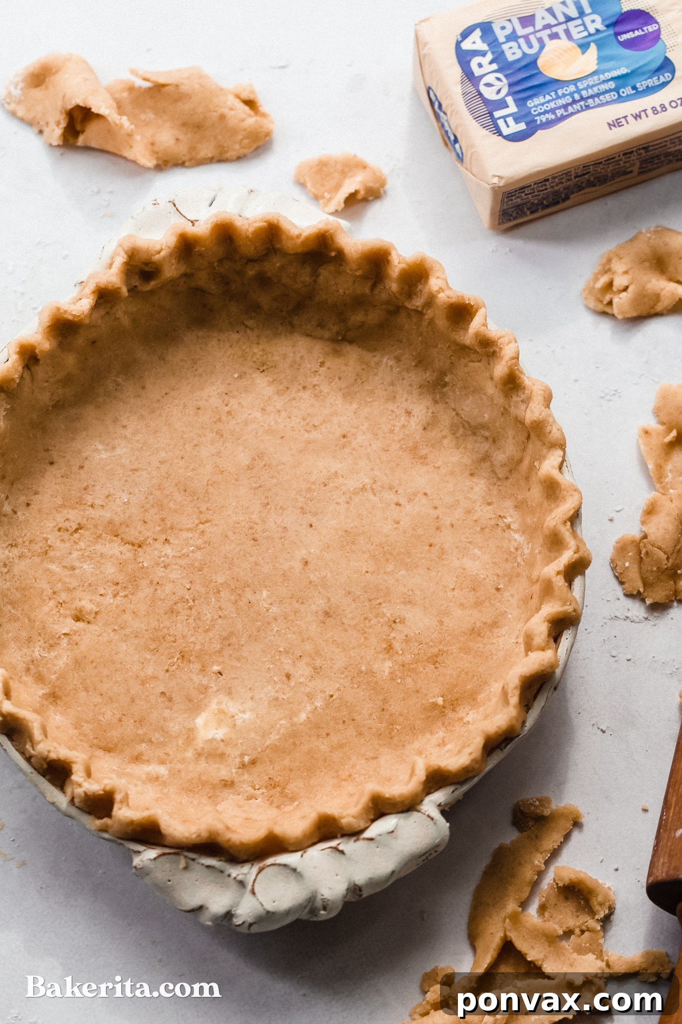 Close-up of the raw gluten-free vegan pie dough being pressed into a pie dish, showing its pliable texture.