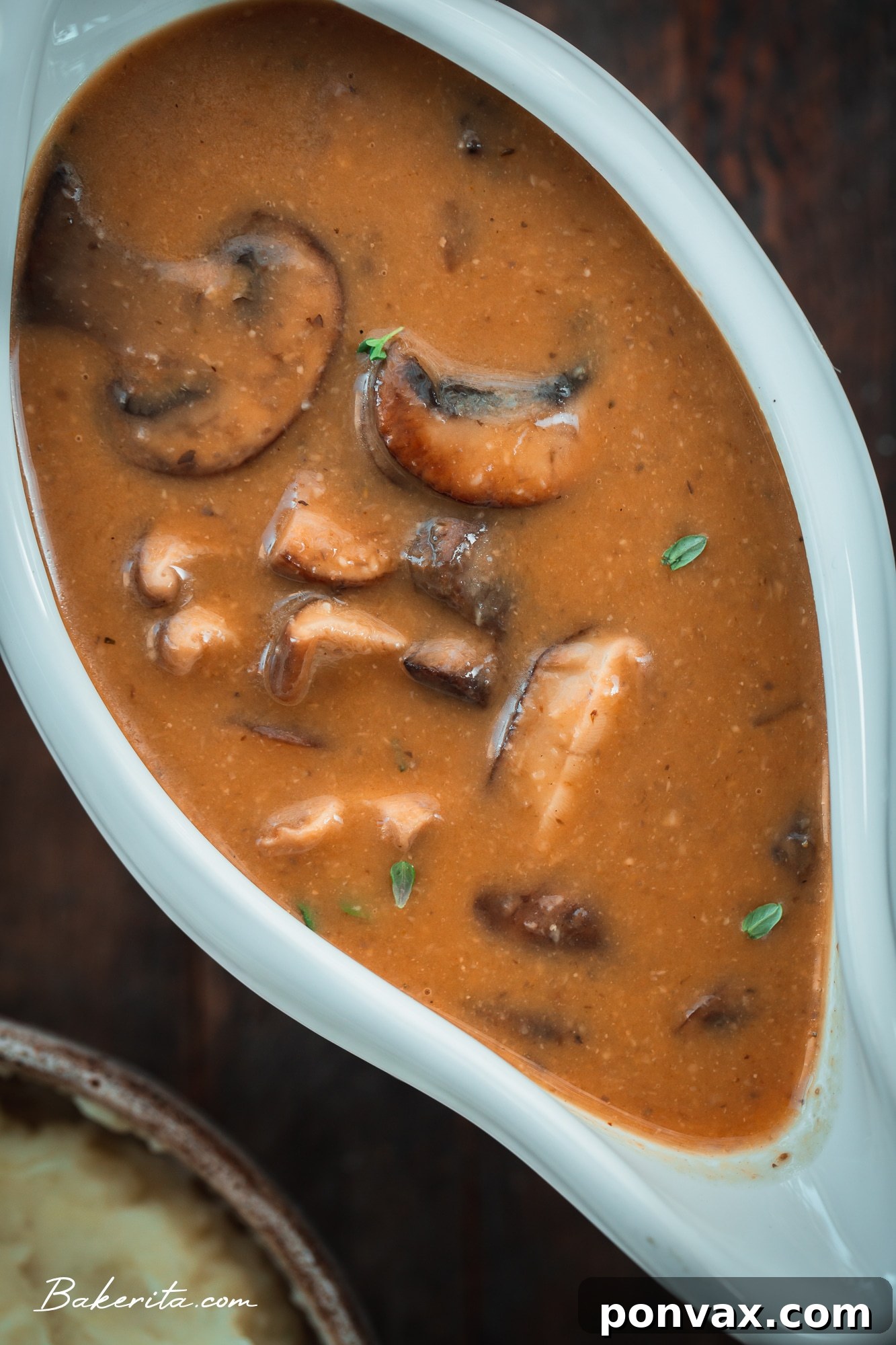 A full holiday plate with mashed potatoes, stuffing, green beans, and vegan mushroom gravy.