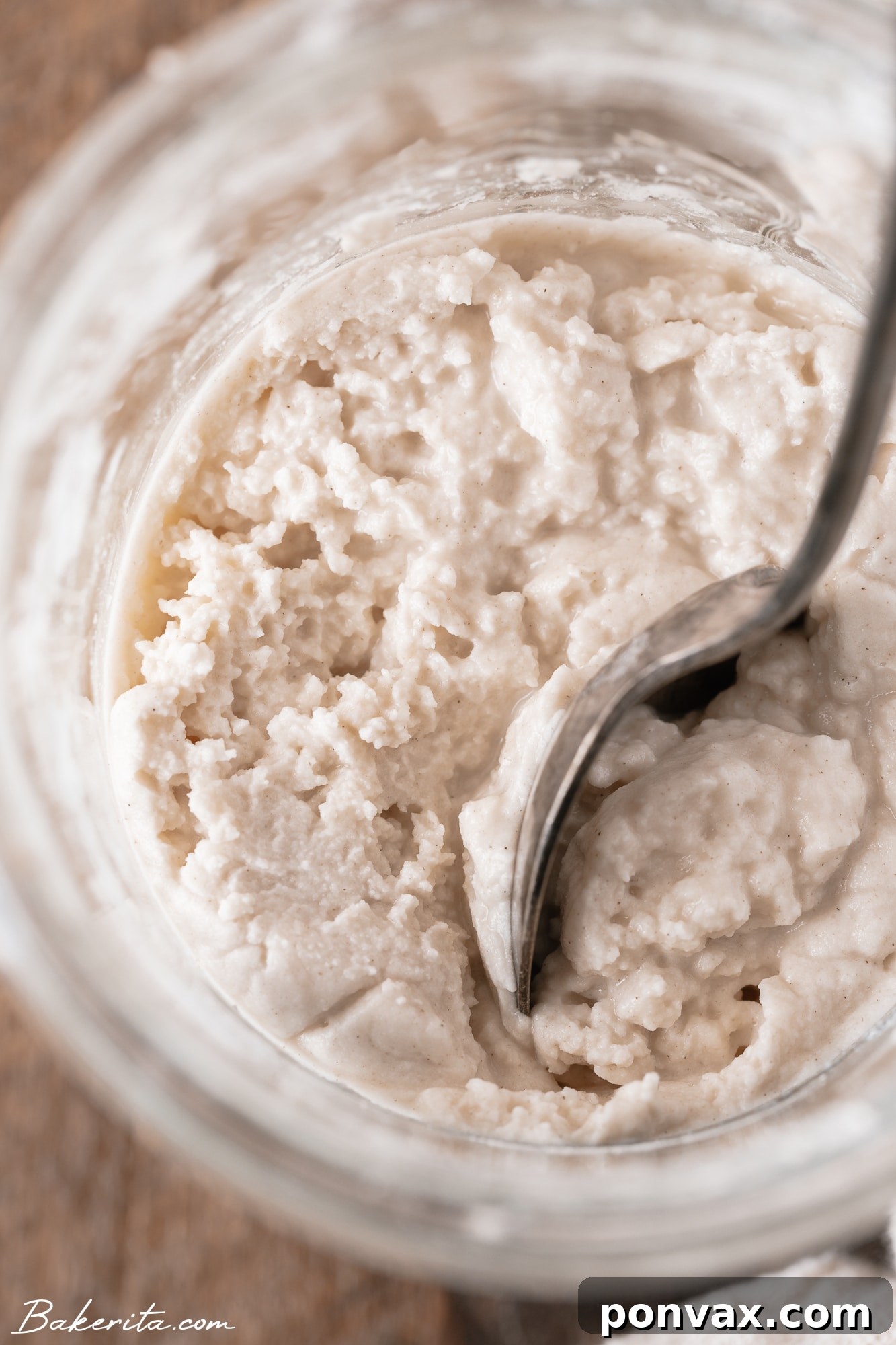 Close-up of a gluten-free sourdough starter showing initial bubbles and a slight rise above the marked line, indicating activity.