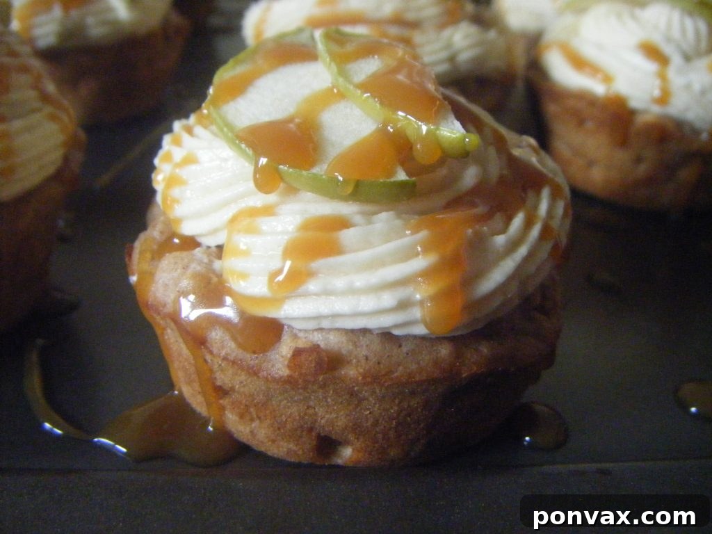 Super moist caramel apple cupcakes with sweet caramel frosting, garnished with apple slices and caramel drizzle, perfect for fall.