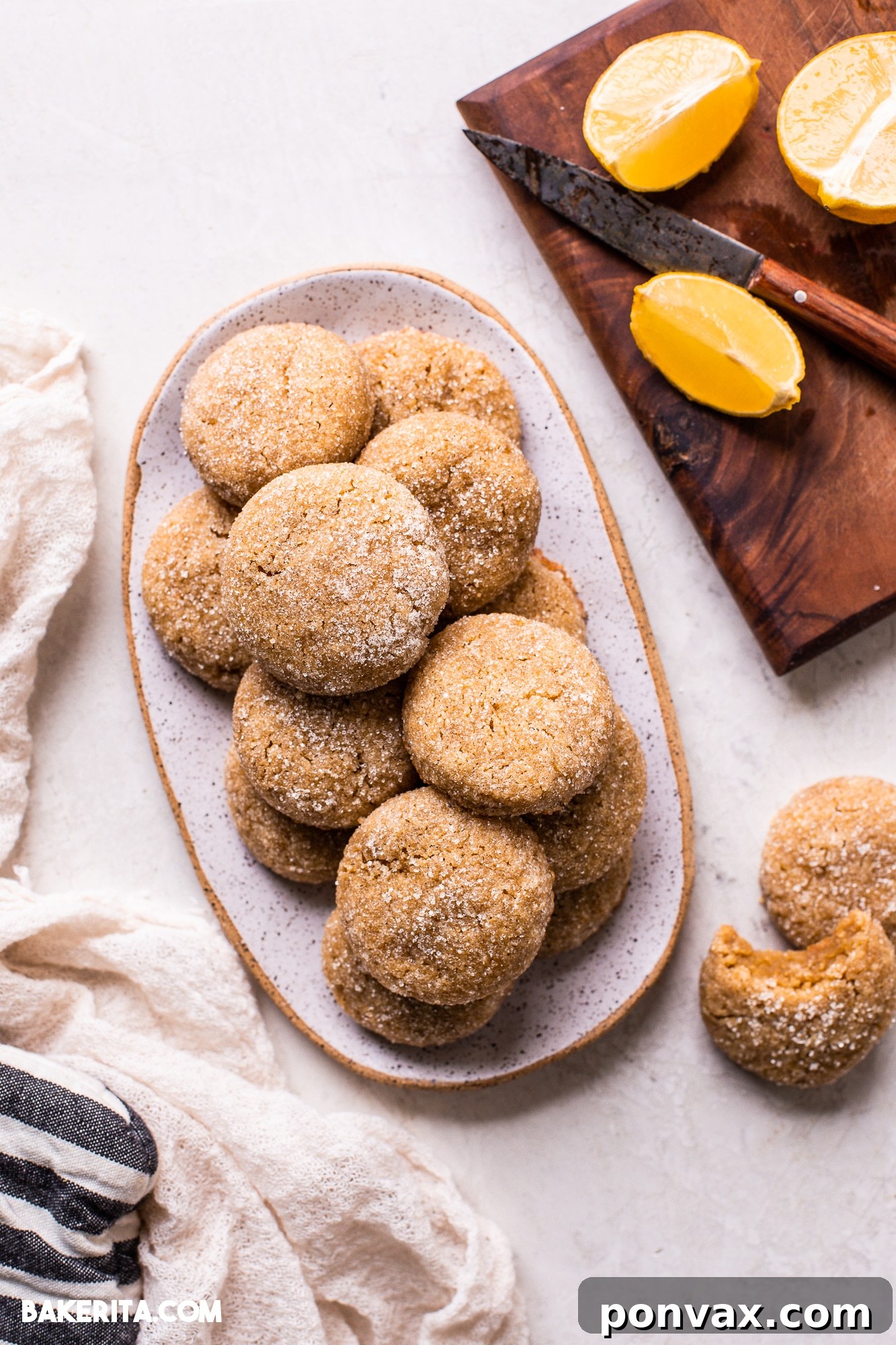 Zesty Soft Chewy Vegan Lemon Cookies 2 Soft and chewy Vegan Gluten-Free Lemon Cookies on a cooling rack, glistening with a sugary coating and bursting with fresh lemon flavor.