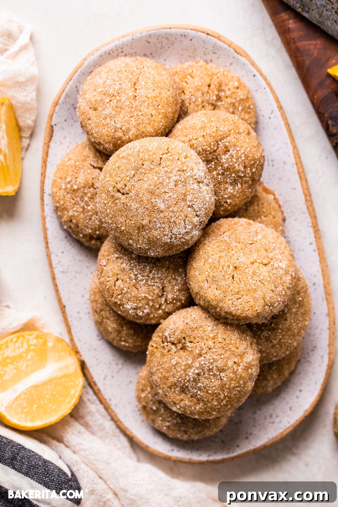 Zesty Soft Chewy Vegan Lemon Cookies 4 Freshly zested and sliced lemons next to a bowl of lemon cookie dough, highlighting the key ingredient.
