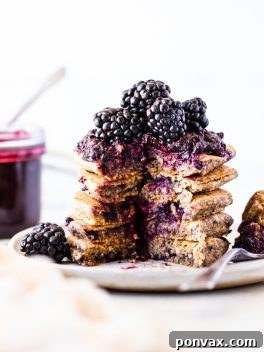Stack of Gluten-Free Vegan Blackberry Pancakes with fresh berries and syrup.