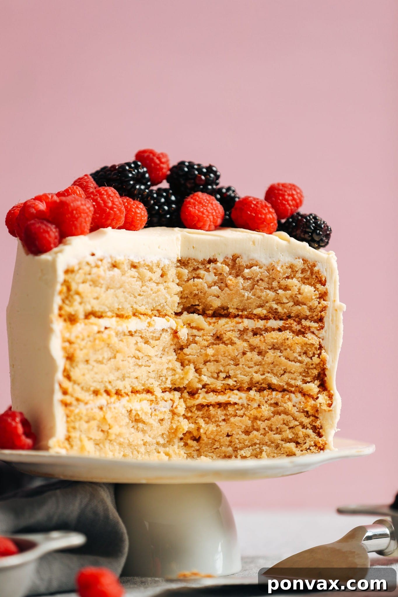 Soft and fluffy one-bowl vegan gluten-free vanilla cake with buttercream and berries by Minimalist Baker.