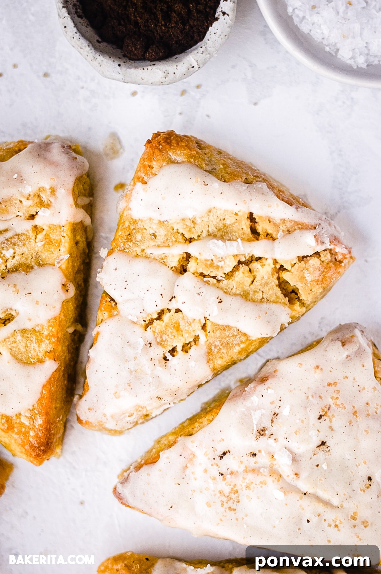 Close up of Vegan Vanilla Bean Scones drizzled with vanilla bean glaze, showcasing the texture and delicious topping.