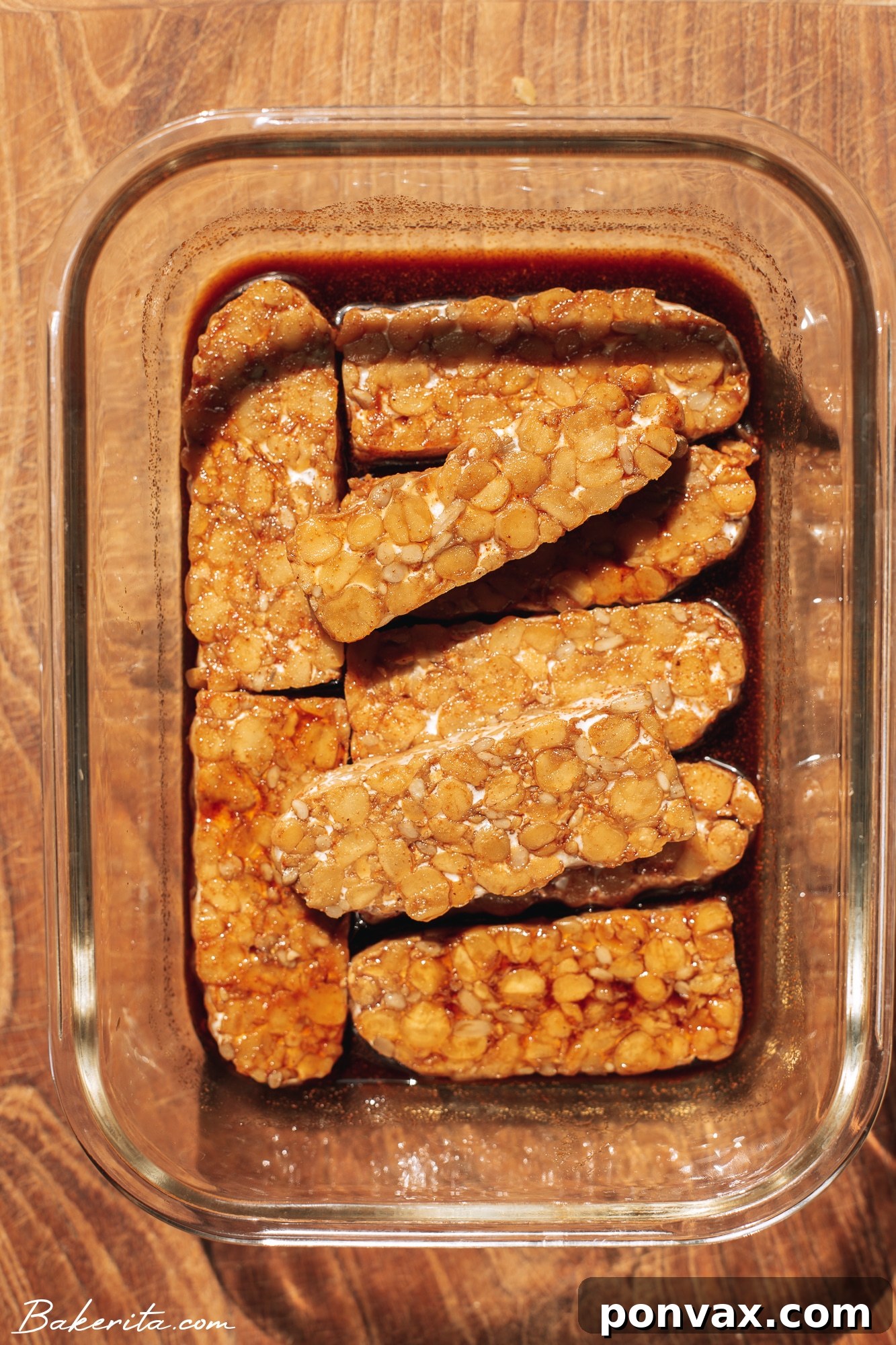 Thinly sliced marinated tempeh ready for cooking, showcasing the rich color from the marinade.