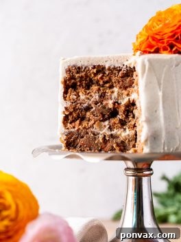 Three Layer Carrot Cake with Vegan Cream Cheese Frosting, close up of the inside of the cake, with flowers on the bottom left side.