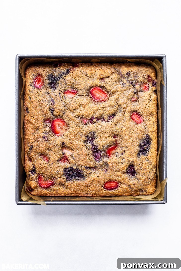 Another close-up, showing the rich texture and colorful berries within the cake.