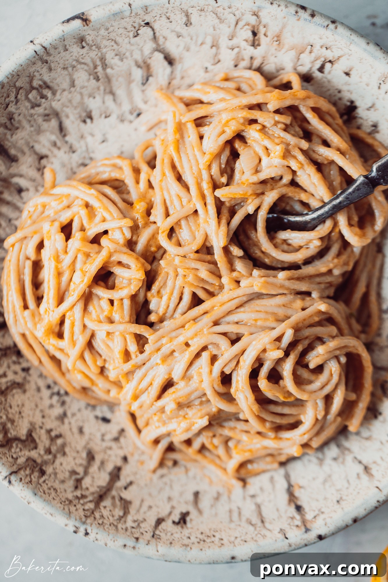Ingredients for one-pot creamy lemon pasta laid out on a wooden surface, including fresh lemons, pasta, coconut milk can, shallots, and garlic.