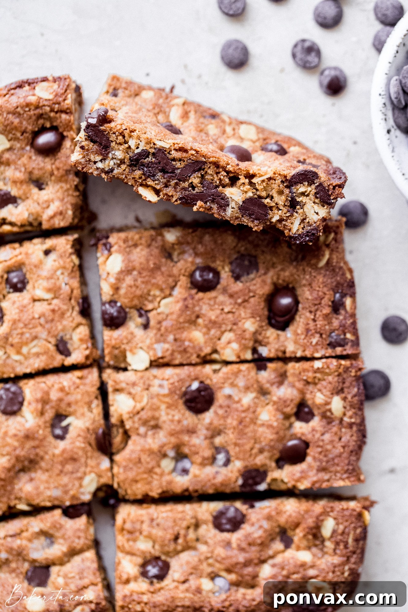 Decadent Plant-Based Oat Chocolate Squares 4 A close-up of a single Vegan Gluten-Free Oatmeal Chocolate Chip Bar, showcasing its soft interior and generous chocolate distribution.