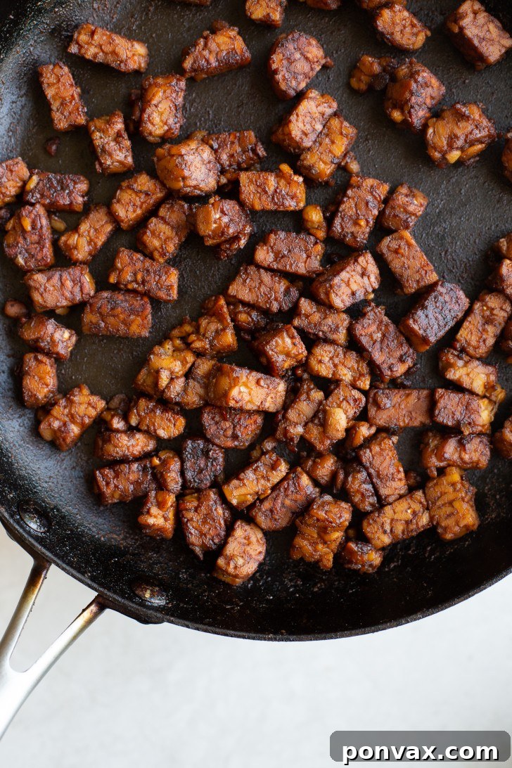 Crispy tempeh bacon strips on a white plate