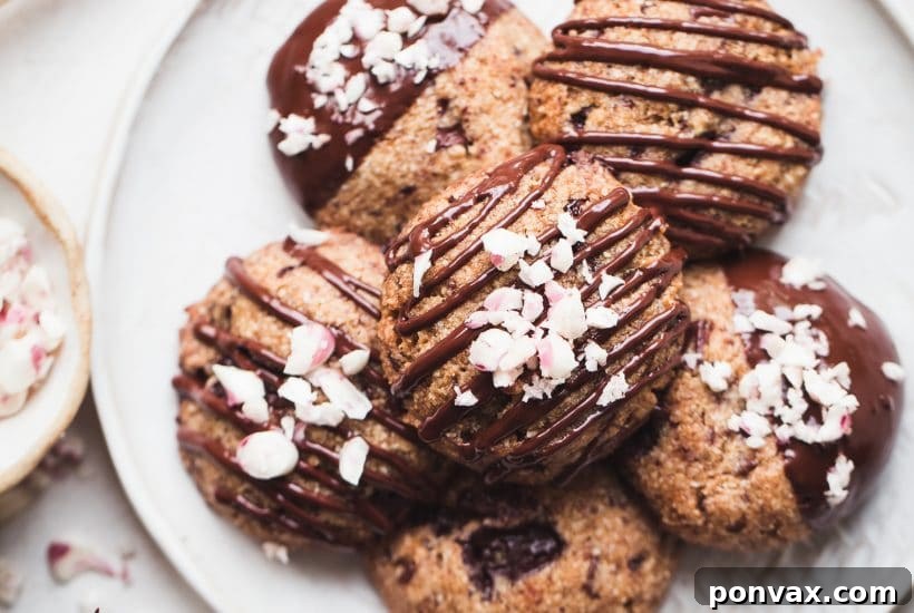25+ Delicious Vegan Cookie Recipes 28 A stack of gluten-free vegan peppermint chocolate chip cookies, drizzled with chocolate and sprinkled with crushed candy canes, set in a festive holiday scene.